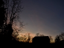 silhouette of barn and surrounding trees during sunset